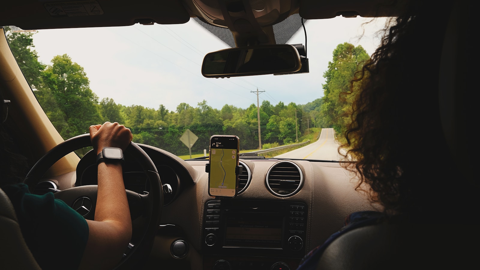 a woman driving a car while holding a cell phone, auto